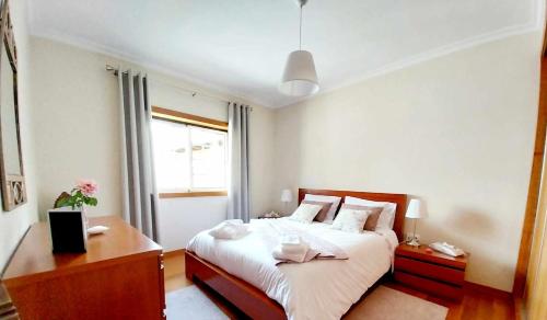 ein Schlafzimmer mit Bett, Schreibtisch und Fenster in der Unterkunft Casa Gloria in Paço Vedro de Magalhães