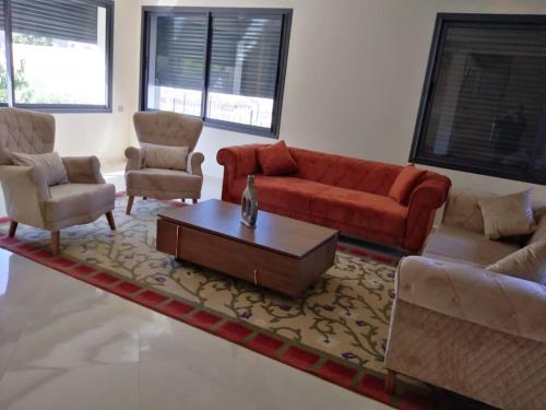 a living room with a red couch and a coffee table at Incantevole villa Safi Sidi Bouzid near beach in Safi