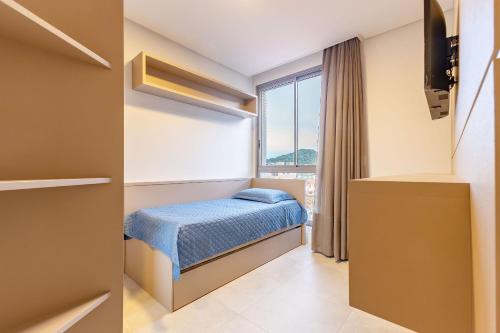 Habitación pequeña con cama y ventana en Porto Madero, Condo com Piscina e Academia -Apto 3 dorms 7 pessoas- Centro de Bombinhas, en Bombinhas