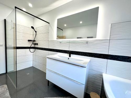 a white bathroom with a sink and a mirror at Ferienwohnung zur Hohe Str in Bad Langensalza