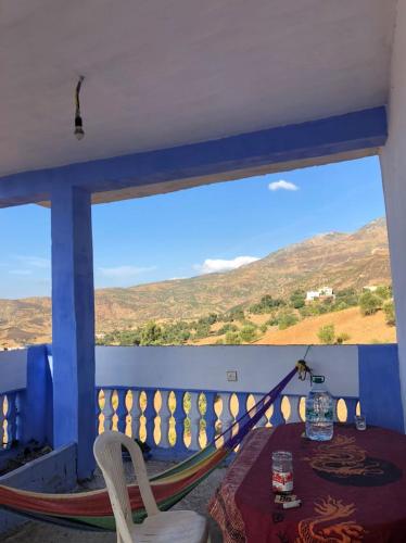 a dining room with a table and a large window at Farm Stay Mharchen in Chefchaouene