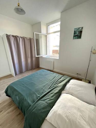 a bedroom with a bed and a window in it at La Liberté I Central I Parking gratuit in Romans-sur-Isère