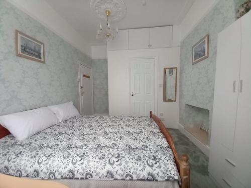 1 dormitorio con 1 cama con edredón blanco y negro en Mari London room for holiday en Ilford