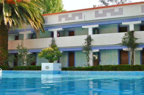 a hotel with a swimming pool in front of a building at Villas Arqueologicas Teotihuacan in San Juan Teotihuacán