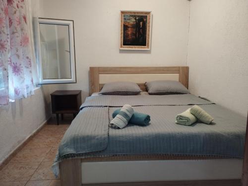 ein Schlafzimmer mit einem Bett mit zwei Kissen darauf in der Unterkunft Vila Katerina Dojran in Sretenovo