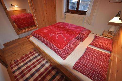 2 camas en una habitación pequeña con mantas rojas en Melchambauer, en Maria Alm am Steinernen Meer