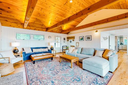 a living room with blue couches and a wooden ceiling at Sea Good in Saint George