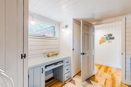 a kitchen with white cabinets and a window at Sea Good in Saint George