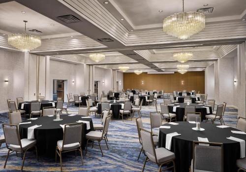 a ballroom with tables and chairs and chandeliers at Sheraton Grand Rapids Airport Hotel in Grand Rapids