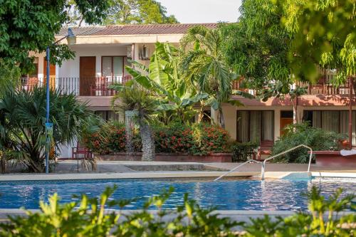 a house with a swimming pool in front of a house at Hotel Boyeros in Liberia