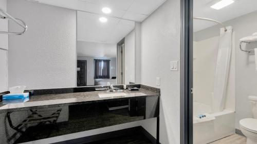 a bathroom with a sink and a toilet and a mirror at Schmidt's Creek Hotel in Osage Beach