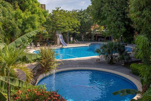 a large swimming pool with a slide in the middle at Hotel Boyeros in Liberia