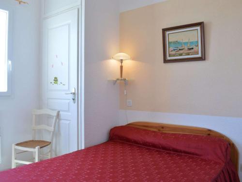 - une petite chambre avec un lit rouge et une chaise dans l'établissement Pavillon climatisé 2 pièces mezzanine, terrasse, parking, 900m plage – Saint-Pierre-la-Mer - FR-1-229D-65, à Fleury