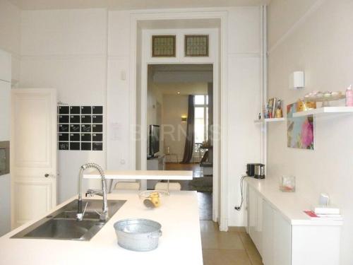 een witte keuken met een wastafel en een aanrecht bij Bed & Breakfast à 20mn direct St Lazare en Train in Sannois