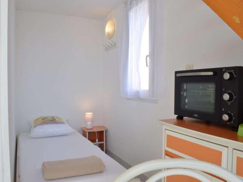 Habitación pequeña con cama y TV. en Maison Narbonne, 2 pièces, 4 personnes - FR-1-229B-39, en Narbona