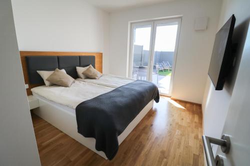 um quarto com uma cama grande e uma televisão em Apartment LaSiesta II em Ptuj