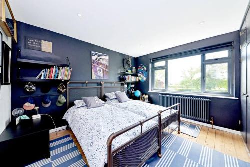 1 dormitorio con cama y pared azul en Stunning, high end country house, en Nether Whitacre