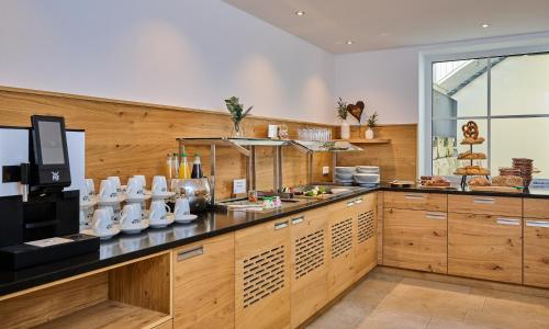 eine Küche mit Holzschränken und einer Arbeitsplatte in der Unterkunft Zum blauen Hecht in Kipfenberg