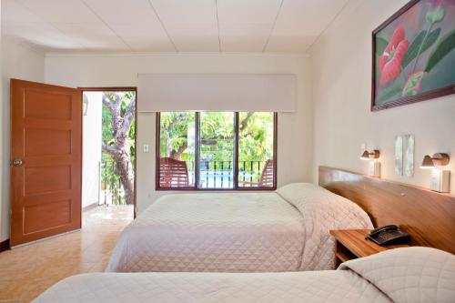 sypialnia z 2 łóżkami i oknem w obiekcie Hotel Boyeros w mieście Liberia