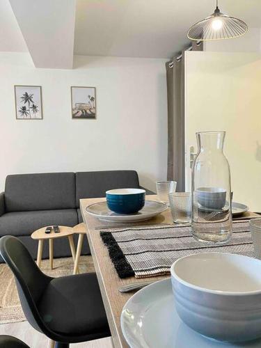 - une table à manger avec des assiettes et un vase dans l'établissement L'Amazonite - Romans, à Romans-sur-Isère