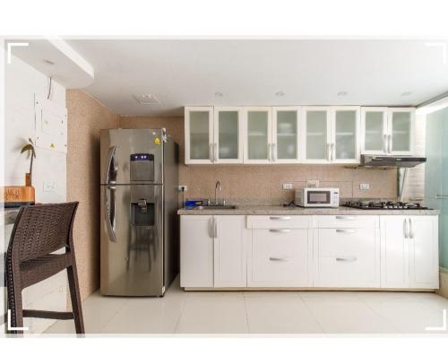 a kitchen with a stainless steel refrigerator and white cabinets at Catedral in Cartagena de Indias