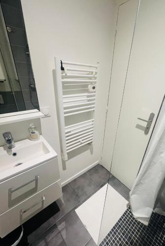 une salle de bain blanche avec un lavabo et une douche dans l'établissement BELLE TOUR, à Reims