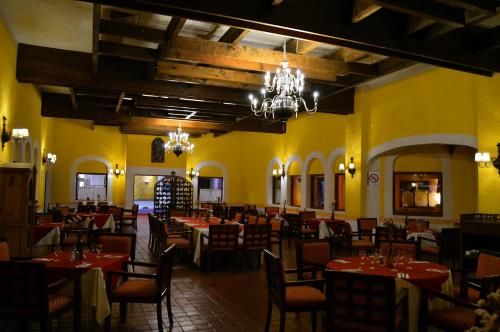 ein Restaurant mit Tischen und Stühlen in einem Zimmer mit gelben Wänden in der Unterkunft Villas Arqueologicas Teotihuacan in San Juan Teotihuacán