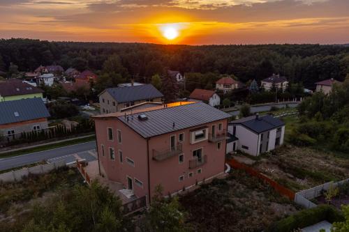 an aerial view of a house with the sunset in the background at LASKARA Garden Apartment by Prague Forest in Nové Jirny