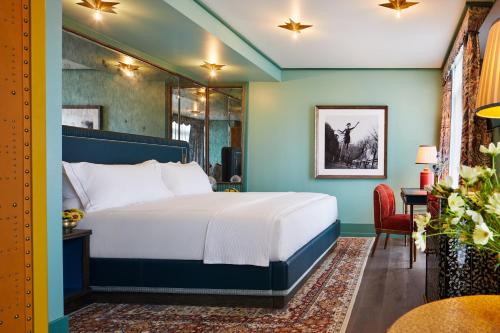 a bedroom with a bed and a desk with a chair at The Fifth Avenue Hotel in New York