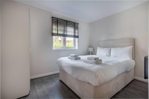 - une chambre blanche avec un grand lit et des serviettes dans l'établissement Lovely 2bed Apt in Redditch, Free Wi-Fi & Parking, à Redditch