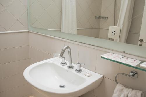 Baño blanco con lavabo y espejo en Gran Hotel Victoria Cordoba Argentina en Córdoba
