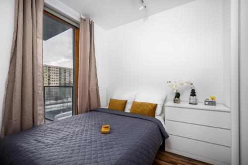 a bedroom with a bed and a large window at Apartament Kasprzaka Bliska Wola in Warsaw