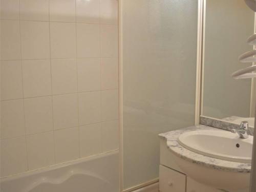une salle de bain blanche avec une douche et un lavabo dans l'établissement Appartement T3 au pied des pistes avec balcon et parking couvert - 2 chambres, 6 couchages - FR-1-593-56, aux Angles