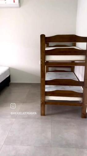 a wooden bunk bed in a room with a tile floor at Área de laser Gabata in Delfinópolis