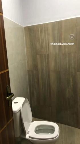 łazienka z białą toaletą w kabinie w obiekcie Área de laser Gabata w mieście Delfinópolis