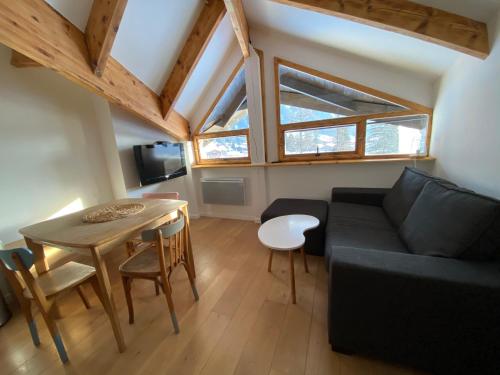 un salon avec un canapé noir et une table dans l'établissement Studio grand montets, à Chamonix-Mont-Blanc