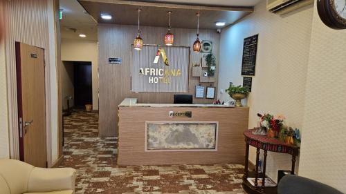 a hotel lobby with a reception desk and a fireplace at Africana Hotel in Dubai