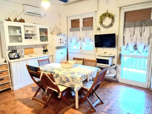 a kitchen with a table and chairs and a television at Alghero Sa Stella Casa Vacanze in Fertilia