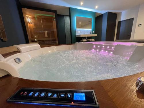 a jacuzzi tub with a thermometer in a bathroom at Loveroom Lens in Lens