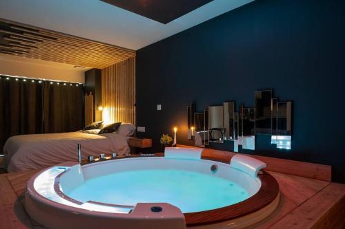 - une grande baignoire dans une chambre avec un lit dans l'établissement Loveroom Lens, à Lens
