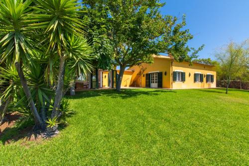 a house with a palm tree in front of a yard at Finca Son Blat in Porto Cristo