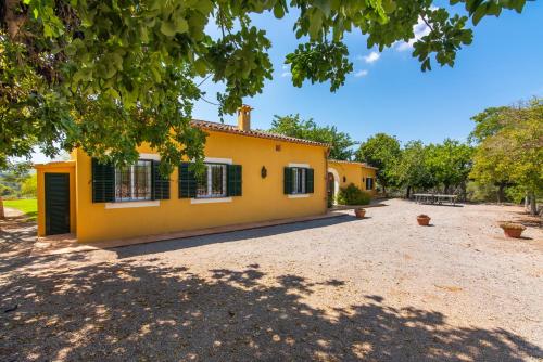 a large yellow house with a yard at Finca Son Blat in Porto Cristo