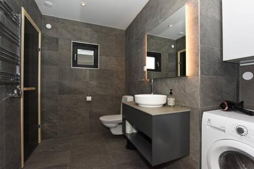 La salle de bains est pourvue d'un lavabo, de toilettes et d'un miroir. dans l'établissement Timmerby Lodge - Lindvallen Sälen - Ski in Ski out, à Sälen