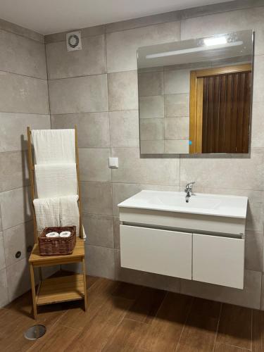 baño con lavabo, espejo y silla en Mike’s House, en Lourinhã