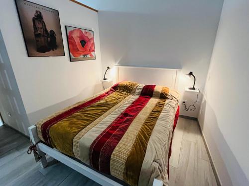 uma cama num quarto com duas lâmpadas na parede em Mike’s House em Lourinhã