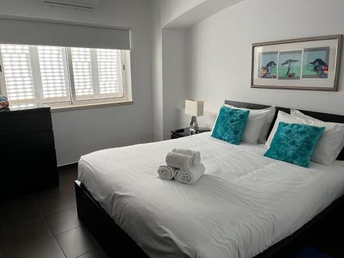 sypialnia z dużym białym łóżkiem z niebieskimi poduszkami w obiekcie House´s Golf w mieście Almancil