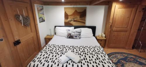 een slaapkamer met een bed met 2 kussens erop bij Chalet 'Les Riaux' - Studio individuel in Chateau-d'Oex