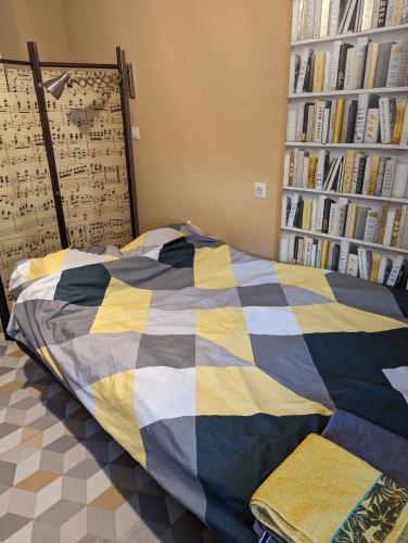 a bedroom with a bed with a colorful comforter at OneRoom in Chełmno