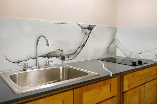 a kitchen with a stainless steel sink on a counter at Days Inn by Wyndham McComb MS in McComb