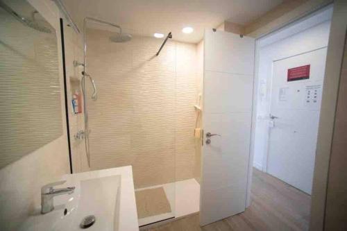 y baño con ducha, lavabo y espejo. en Renovated apartment in La Manga with great sunset, en La Manga del Mar Menor